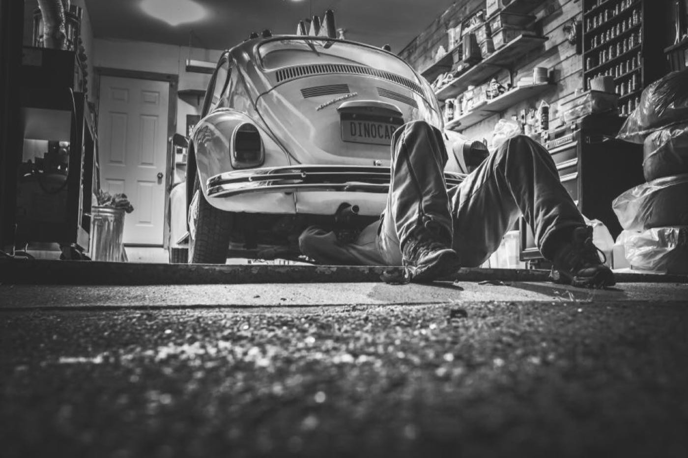 A mechanic working under a car, illustrating garage website online booking