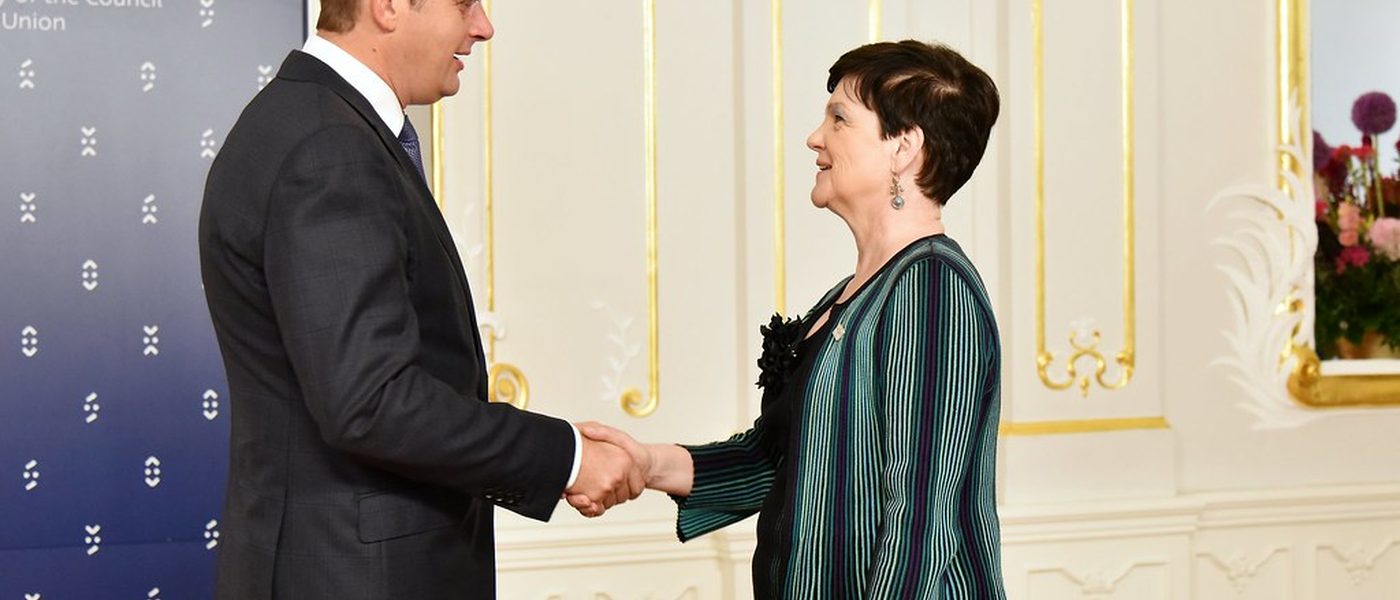 Two people shaking hands over a table, illustrating a quote being won